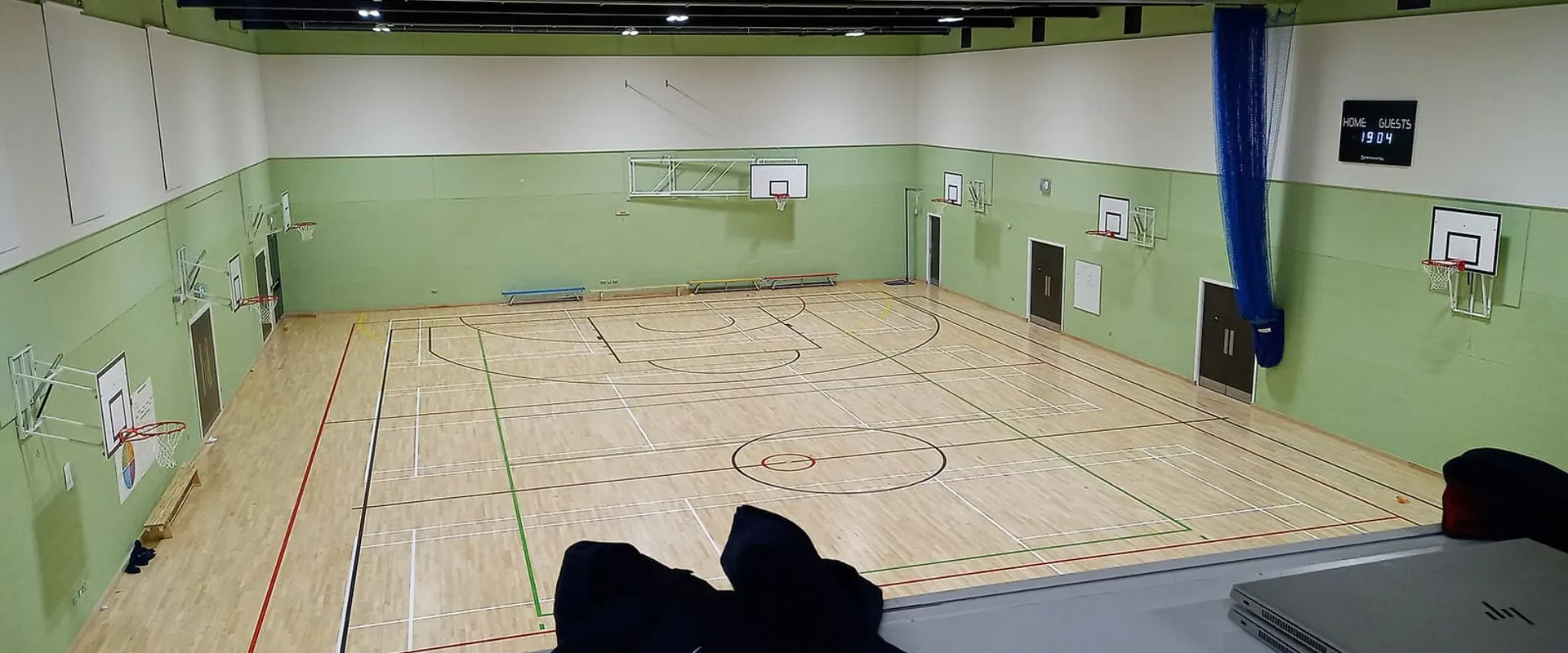 La palestra con il parquet, i canestri e le spalliere lungo la parete