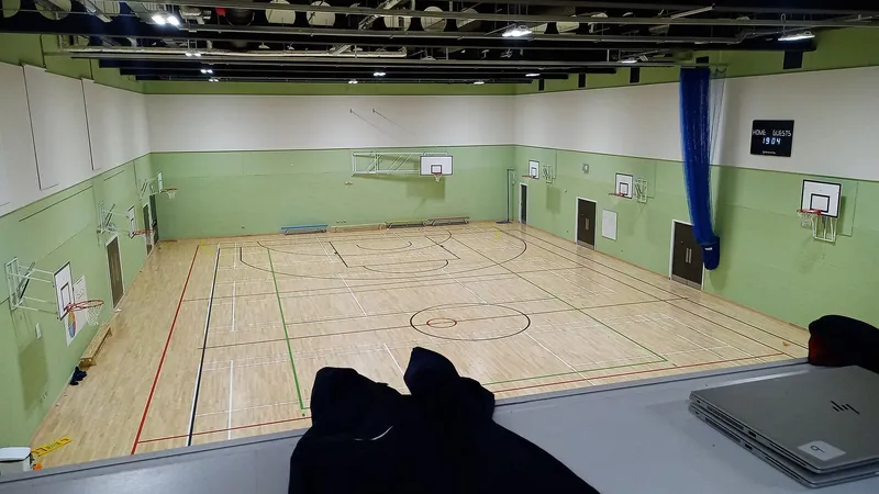 La palestra con il parquet, i canestri e le spalliere lungo la parete