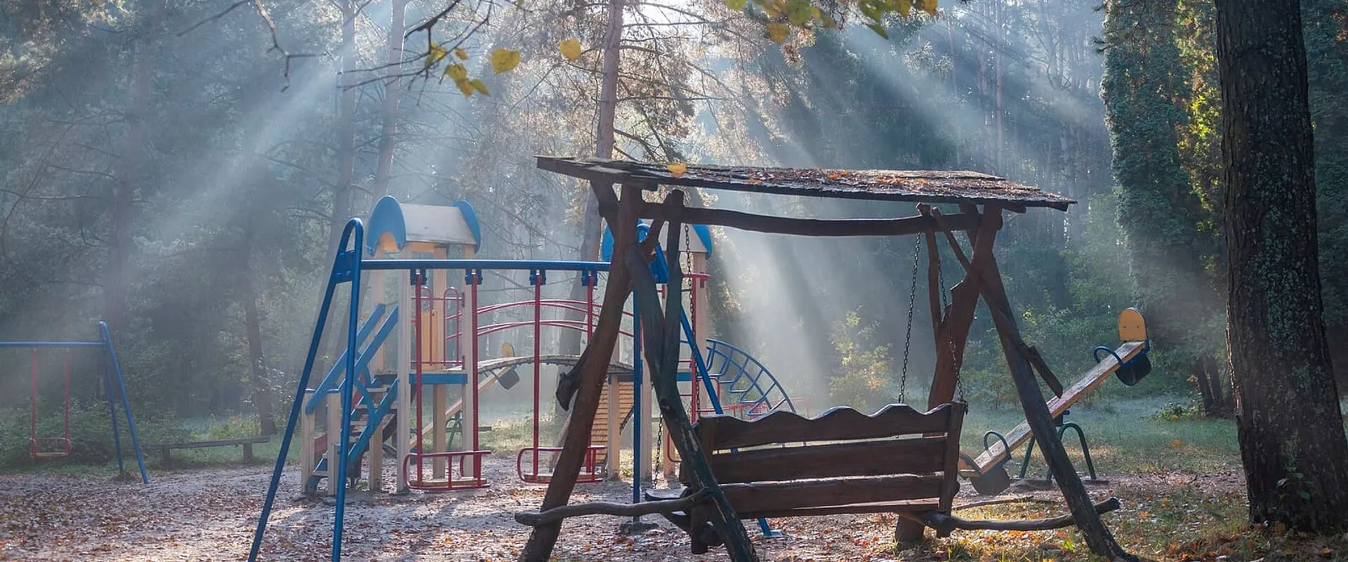 Il giardino della scuola dell’infanzia con i giochi colorati all’ombra degli alberi